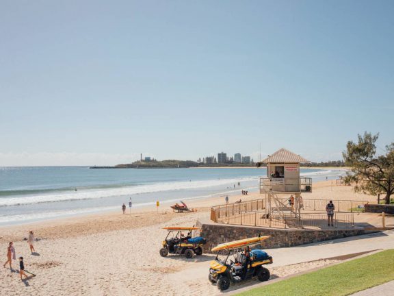 mooloolaba-surf-club-beach-view-with-surf-lifesaving-tower-and-vehicles