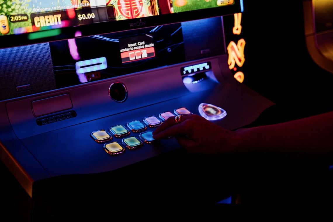 mooloolaba-surf-club-gaming-lounge-woman-pressing-buttons-on-poker-machine