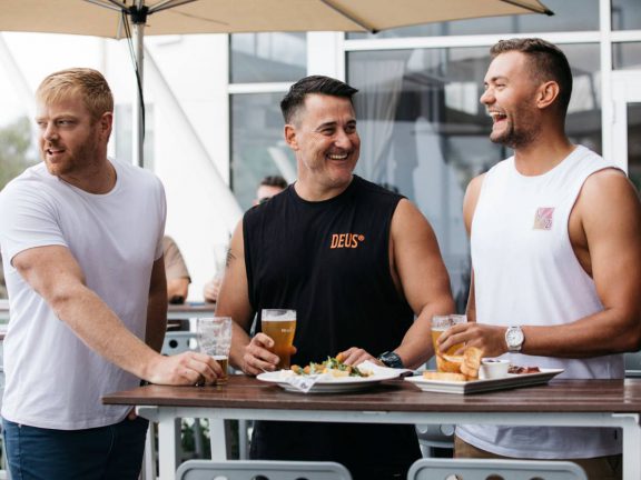 mooloolaba-surf-club-three-men-enjoying-beer-on-deck