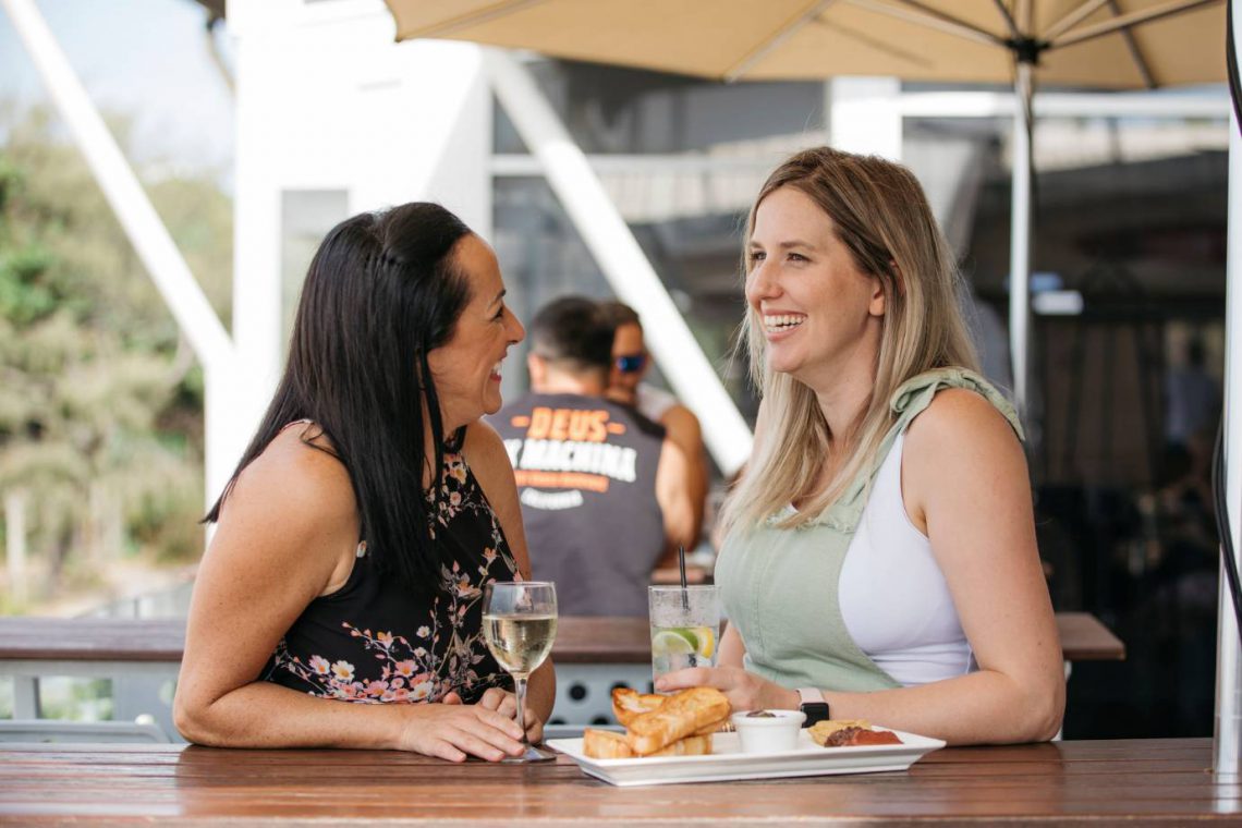 mooloolaba-surf-club-two-women-smiling-and-talking-on-deck