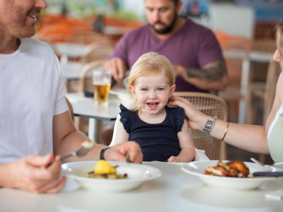 mooloolaba-surf-club-young-family-enjoying-meal-with-smiling-child